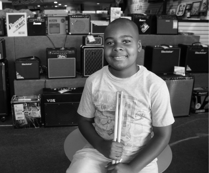 Young boy smiling in a music shop